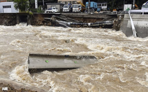 2021年8月の大雨で増水した広島市安佐北区の鈴張川。後方は崩落した道路=共同