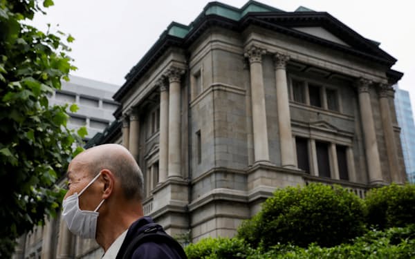 FILE PHOTO: A man wearing a protective mask stands in front of the headquarters of Bank of Japan amid the coronavirus disease (COVID-19) outbreak in Tokyo, Japan, May 22, 2020.REUTERS/Kim Kyung-Hoon/File Photo