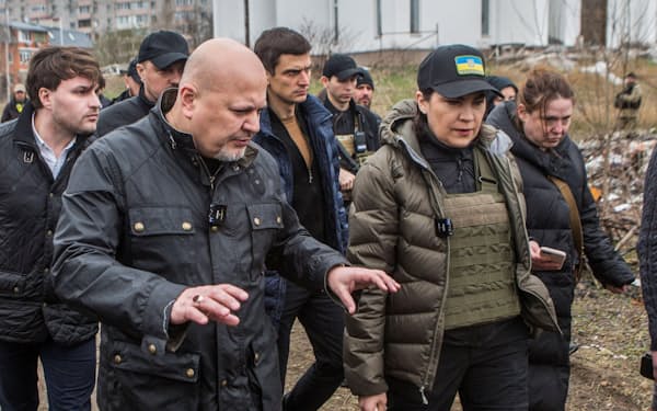 4月、ウクライナ・ブチャで、遺体が埋められた現場を訪れたICCのカーン主任検察官（左手前）=ロイター