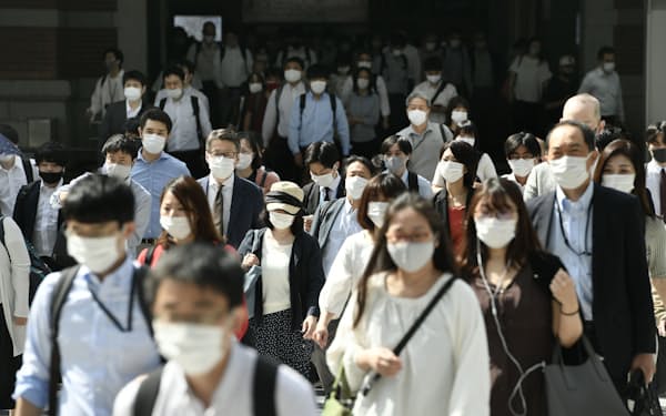 マスク姿で出勤する人たち（18日午前、東京・丸の内）