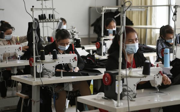 縫製工場で働くウイグル族の作業員（2021年5月、中国新疆ウイグル自治区カシュガル）＝共同