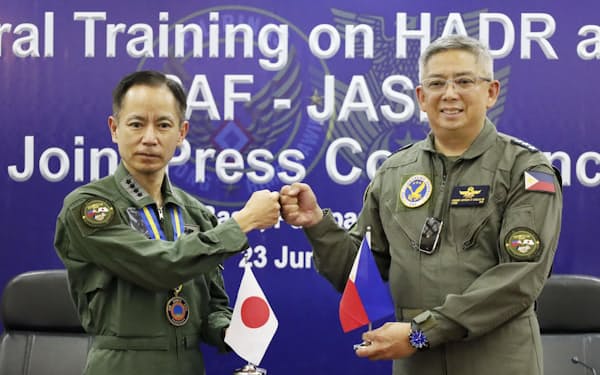井筒俊司航空幕僚長（左）とフィリピン空軍のカンラス司令官（23日、フィリピン・クラーク空軍基地）＝共同