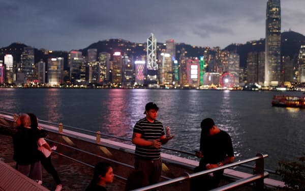 People rest at the Victoria Harbour during sunset, ahead of the 25th anniversary of Hong Kong's handover to China from Britain, in Hong Kong, China May 17, 2022. Picture taken May 17, 2022. REUTERS/Tyrone Siu