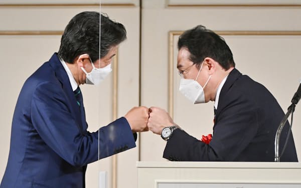自民党安倍派のパーティーで安倍元首相とグータッチをする岸田首相（17日午後、東京都港区）