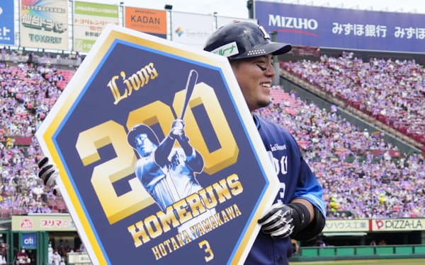 4回、日本選手最速となる通算200本塁打を達成し、記念のボードを手にする西武・山川（26日、楽天生命パーク）＝共同