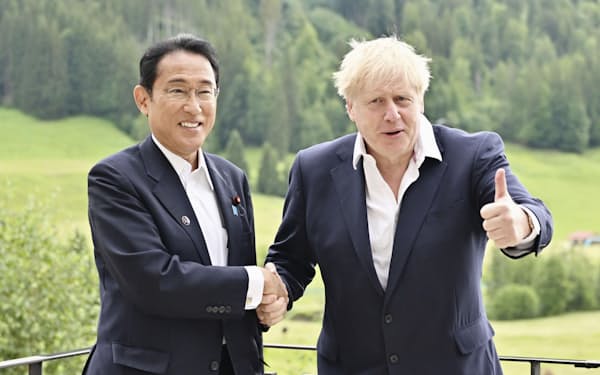　会談で握手する岸田首相（左）とジョンソン英首相＝28日、ドイツ南部エルマウ（代表撮影・共同）