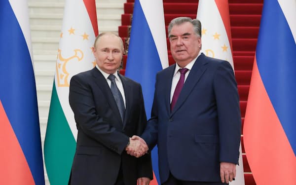 　握手するロシアのプーチン大統領（左）とタジキスタンのラフモン大統領＝28日、ドゥシャンベ（タス＝共同）