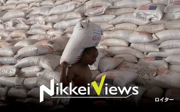 国連機関の倉庫から援助物資で届いた小麦を運ぶ、干ばつの避難民キャンプの男性(4月、エチオピア)=ロイター