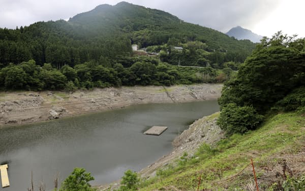 水位が下がった早明浦ダム。中央は水面に出現した旧大川村役場庁舎の一部（6月28日、高知県大川村）=共同