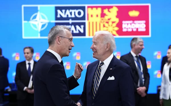 NATO首脳会議で会話するストルテンベルグ事務総長（左）とバイデン米大統領（30日、スペイン・マドリード）＝AP