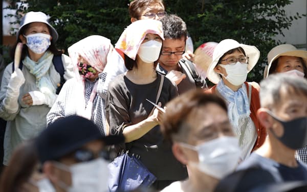 強い日差しの中、街頭演説に耳を傾ける人たち(1日、大阪市)=共同