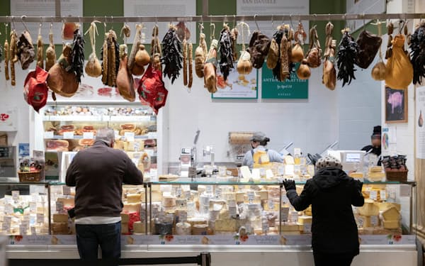 ニューヨーク・マンハッタンのスーパーマーケットで肉・チーズの売り場の商品を見る買い物客＝ロイター