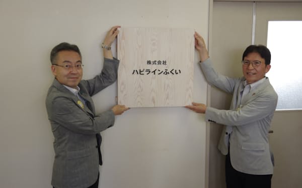 福井県の杉本達治知事（左）らが掛けた看板には県産杉が使われている（４日、福井市）