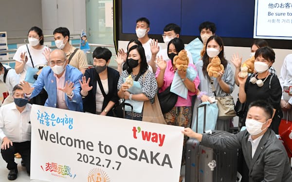 関西国際空港に到着し、記念撮影する韓国からの団体観光客（7日午前）