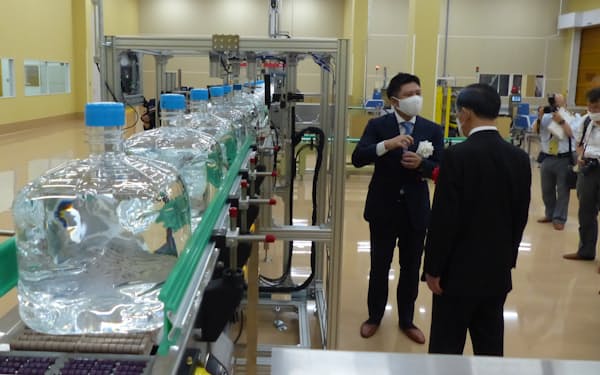 完成したビックカメラグループの天然水工場の製造ライン。富士吉田市の堀内茂市長が説明を受けた（7日）