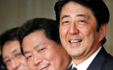 FILE PHOTO: Japan's prime minister-in-waiting Shinzo Abe smiles with newly appointed Secretary General Hidenao Nakagawa and General Council Chairman Yuya Niwa of his ruling Liberal Democratic Party at a party executive meeting in Tokyo September 25, 2006.  REUTERS/Toshiyuki Aizawa/File Photo