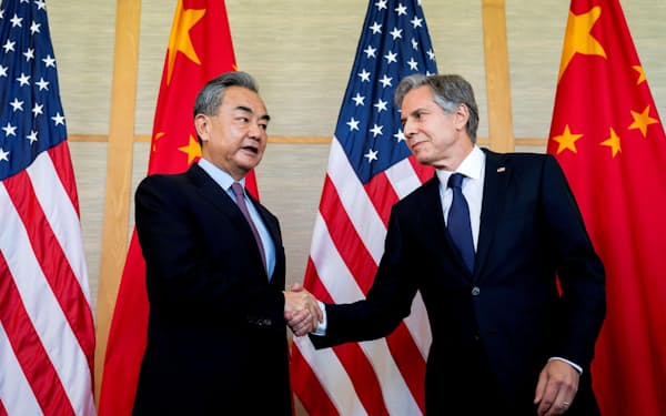 9日、握手を交わす中国の王毅国務委員兼外相（左）とブリンケン米国務長官（バリ島）＝ロイター