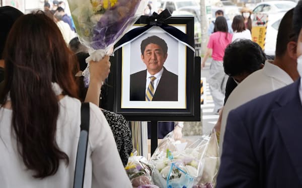 銃撃現場近くの献花台に掲げられた安倍元首相の遺影（10日、奈良市）