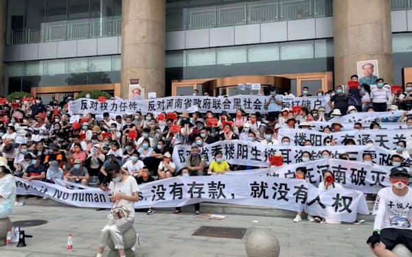 中国河南省鄭州市の中国人民銀行前で、地元銀行の預金引き出し停止に抗議する人々（10日）＝ロイター