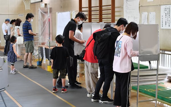 参院選の投票所で、投票用紙に記入する有権者ら（10日午前、東京都新宿区）