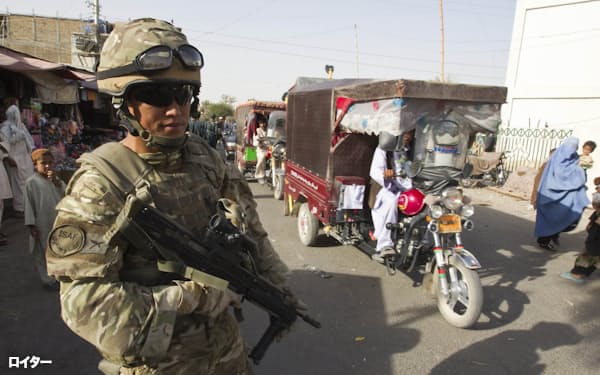  2011年7月、アフガニスタン南部ヘルマンド州ラシュカルガーで、警察署付近をパトロールする英軍兵士(ロイター=共同)