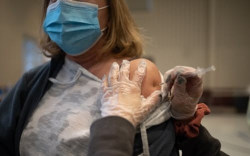 2022年4月5日火曜日、クリニックで新型コロナワクチンのブースター接種を受ける研修医。（PHOTOGRAPH BY HANNAH BEIER, BLOOMBERG/GETTY IMAGES）