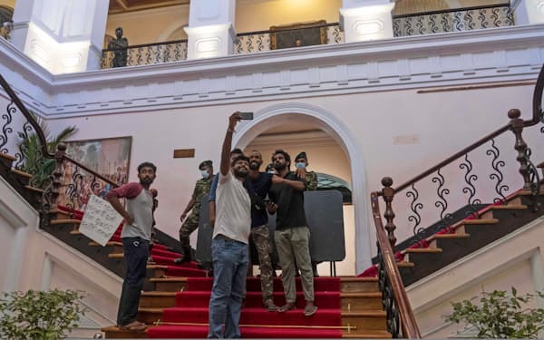 14日、占拠したコロンボの大統領公邸で写真を撮る市民ら＝AP