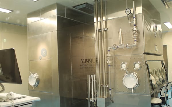 武田薬品工業大阪工場内にある細胞処理室。銀色の装置はクリーン度が高いアイソレーター（無菌化装置）。ここに両腕を挿入し、細胞の培養や瓶への充填などの作業を行う