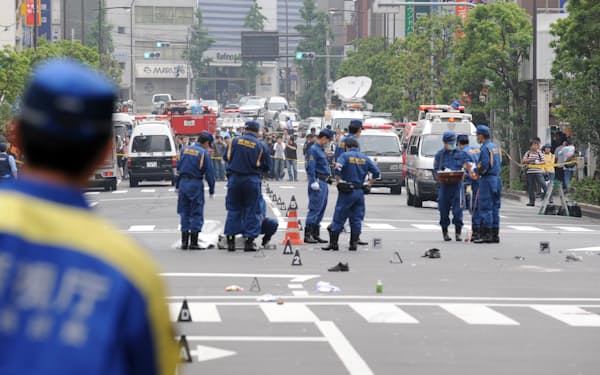 東京・秋葉原で歩行者らがトラックではねられるなどの無差別殺傷事件が起き、現場検証する警視庁の捜査員(2008年6月)
