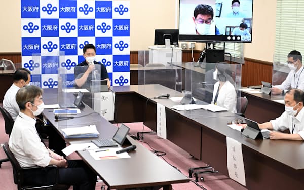 大阪府の新型コロナウイルス対策本部会議で発言する吉村知事（左奥）=27日午後、大阪府庁