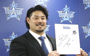 契約を更改し、色紙を手にするDeNA・宮崎(17日、横浜市)=共同