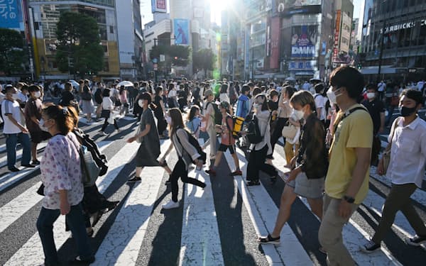東京・渋谷のスクランブル交差点をマスク姿で歩く人たち（29日）