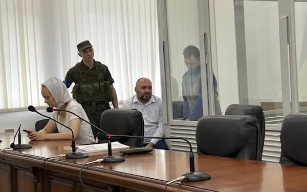 戦争犯罪を問われているロシア兵（右、ガラス越しの人物）に対しウクライナの控訴裁判所は減刑を決めた（29日）＝ＡＰ