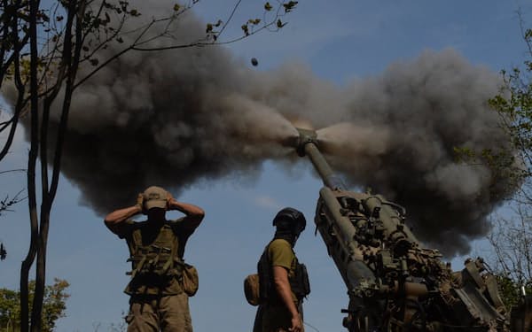 りゅう弾砲を発射する前線のウクライナ兵士ら（1日、ハリコフ州）=ロイター