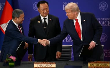 10月下旬、トランプ米大統領㊨が仲介した和平合意の調印式は終始和やかな雰囲気だった(クアラルンプール)=ロイター