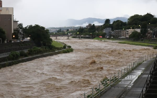 金沢市中心部を流れる犀川は大雨で増水し、茶色く濁った（4日午後）