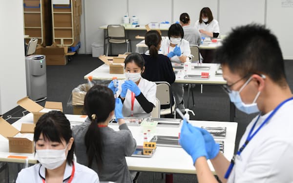 働く主婦の「収入の壁」はワクチン接種の現場にも影響した（新型コロナウイルスワクチンを注射器に移す看護師ら、大阪中央区、2022年２月）