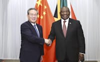 握手する中国の李強首相㊧と南アフリカのラマポーザ大統領(21日、ヨハネスブルク)=新華社・共同