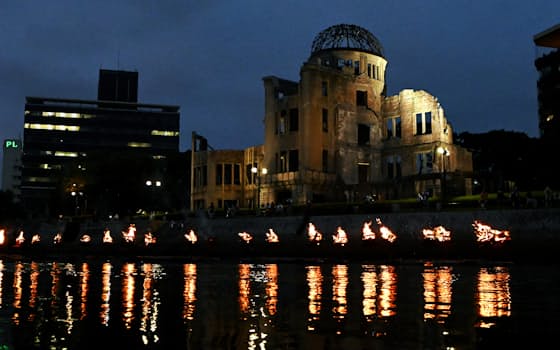 原爆投下から77年の「広島原爆の日」を前に、原爆ドーム前の元安川を照らすかがり火（5日夜、広島市中区）=森山有紗撮影