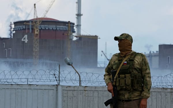 ロシア軍関係者とみられる人がウクライナ南部ザポロジエ原発の近くに立つ（4日）=ロイター