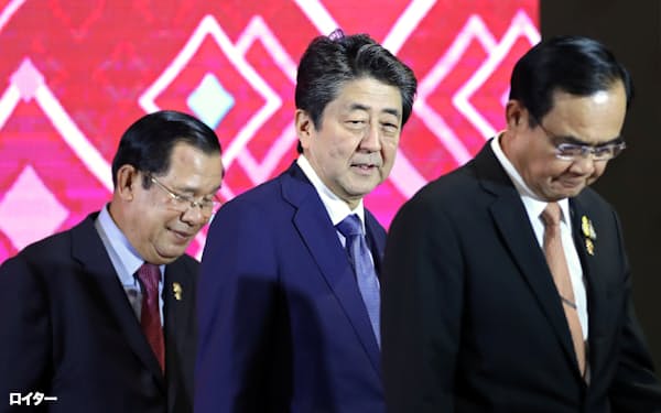 日本ASEAN首脳会議で安倍氏と並ぶカンボジアのフン・セン㊧、タイのプラユット両首相(バンコク、2019年11月)=ロイター