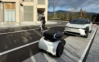 写真手前が3輪の小型自動運転車「ガイドモビ」で、後ろの自動車を仮想的にけん引する(写真:日経Automotive)