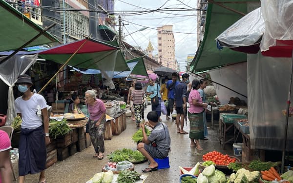 7月下旬、ヤンゴンの市場で買い物をする人々