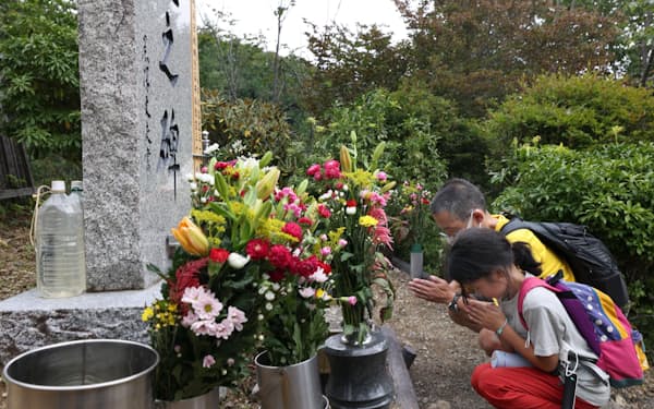 犠牲者の冥福を祈り「昇魂之碑」に手を合わせる遺族（12日午前、群馬県上野村）