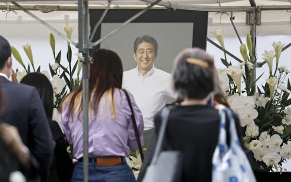 安倍元首相の葬儀会場に設けられた献花台に花を手向ける人たち（7月12日、東京・芝公園の増上寺）
