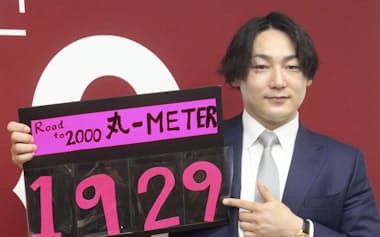 契約交渉を終え、通算安打数のボードを手に撮影に応じる巨人・丸(3日、東京都内)=共同
