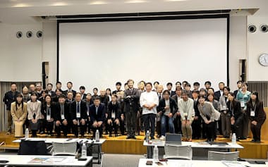 山形大学鶴岡ガストロノミックイノベーション研究所の研究員とコンソーシアム参画企業の社員が記念写真に納まった。白いコックコートを着て前列に立つのが講師を務めた奥田シェフ。左隣は冨田所長、右隣はメタジェンの福田社長(11月、山形県鶴岡市)