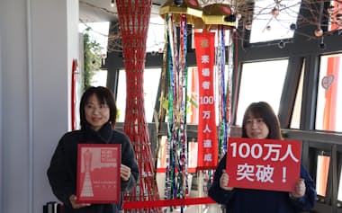 神戸ポートタワーの再開業後、100万人目の来場者になった東さん㊧(4日、神戸市)