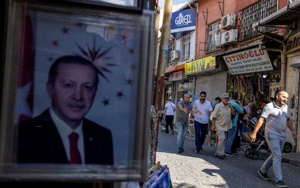 イスタンブール市民の生活にも物価高は重くのしかかる（７月、左はエルドアン大統領の肖像）＝ロイター