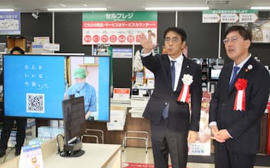 店舗中央のコミュニティースペースを紹介する竹増社長㊧と徳永繁樹・今治市長